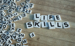 3D rendering of the words life skills written on letter tiles against a wooden background