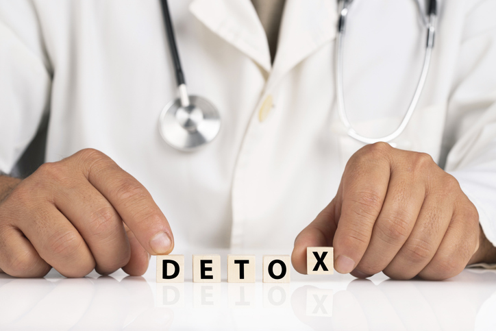 Doctor spelling out detox with letter blocks