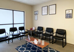 Lobby with white walls and black chairs along the walls with a coffee table in the center of the room displaying informational brochures