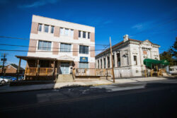 Outside view of a 3 story concrete and brick building on the left and an old cement bank building on the right converted into the treatment center