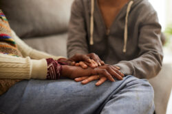 A woman with cancer and her daughter hand in hand.