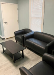 blue colored room with black couches and a coffee table