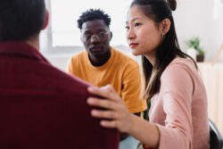 Meeting of young people in group therapy supporting each other